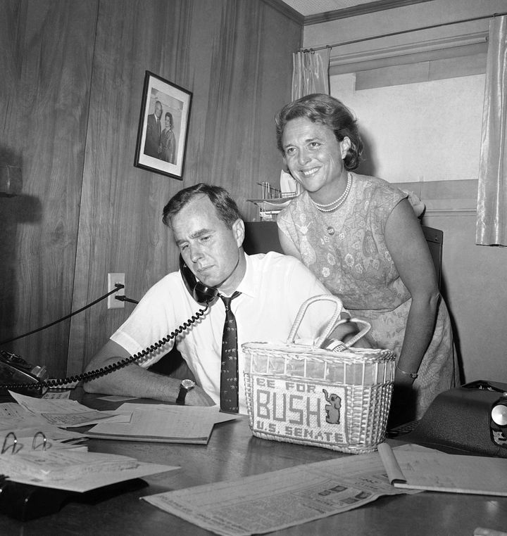 In this June 6, 1964, file photo George H.W. Bush, candidate for the Republican nomination for the U.S. Senate, gets returns by phone at his headquarters in Houston, as his wife Barbara, smiles at the news. Bush died at the age of 94 on Friday, Nov. 30, 2018, about eight months after the death of his wife, Barbara Bush. (AP Photo/Ed Kolenovsky, File)