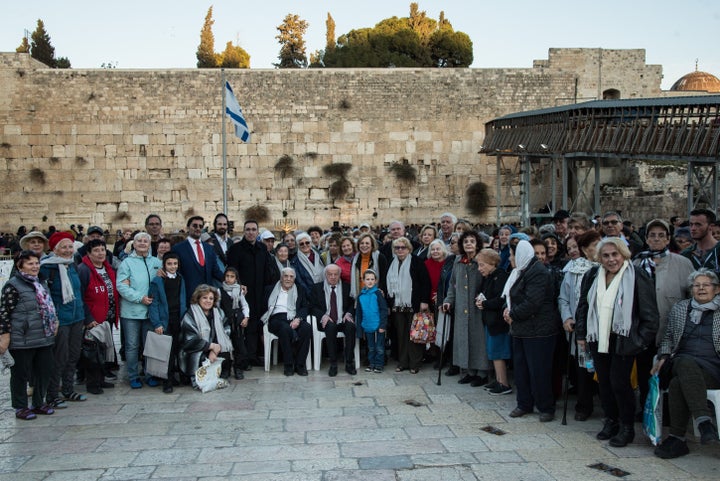 Claims Conference leaders and Holocaust survivors stand at Jerusalem's Western Wall before a menorah lighting.