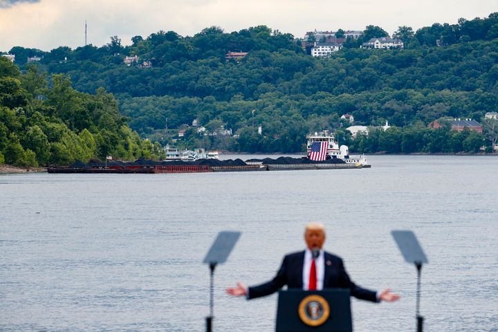 In this June 7, 2017 file photo, a coal barge is positioned as a backdrop behind President Donald Trump as he speaks during a rally at the Rivertowne Marina in Cincinnati.