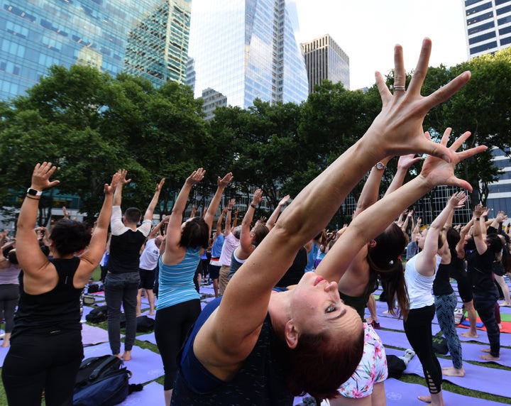People participate in a free outdoor yoga event in Bryant Park in New York City July 12, 2018. (Photo by TIMOTHY A. CLARY / A