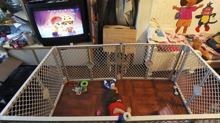 Alexander, 2, a disabled foster child, lies on a mat in a playpen at his Philadelphia foster home. The nation’s affordable housing crisis may be contributing to a dearth of available foster families. 