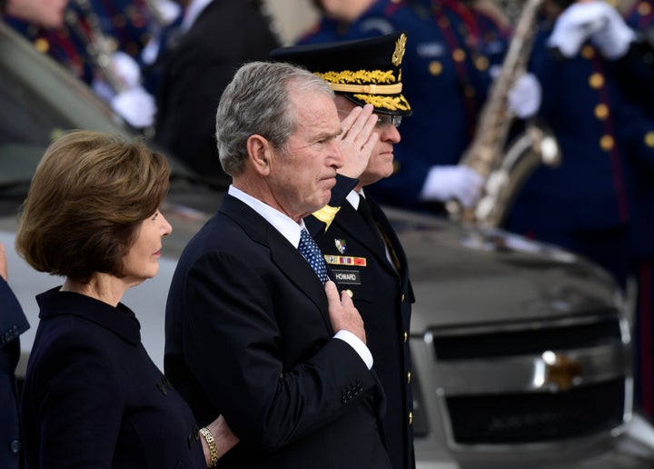 George W. Bush is seen beside his wife, Laura Bush, as the casket of his late father arrives at the National Cathedral.