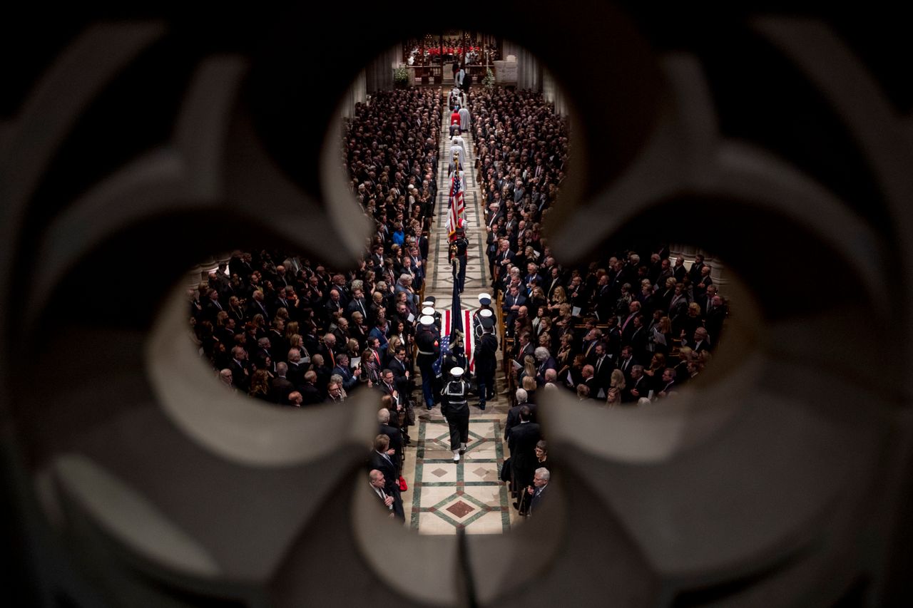 The flag-draped casket of former President George H.W. Bush is carried by a military honor guard into a State Funeral at the National Cathedral.