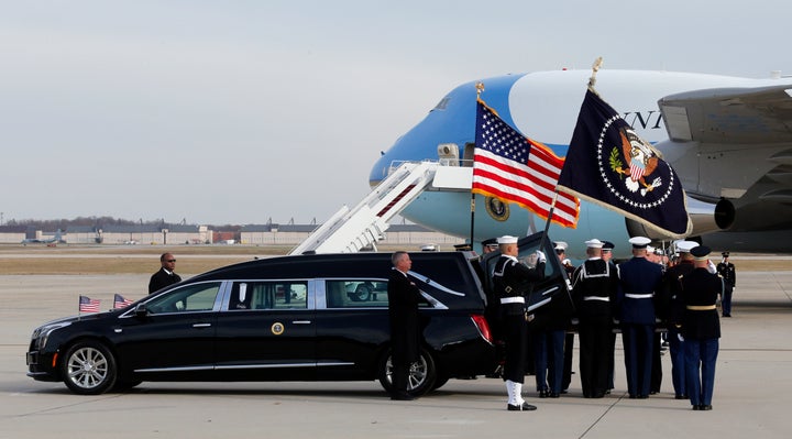 The flag-draped casket of former President George H.W. Bush is carried by a joint services military honor guard during a depa