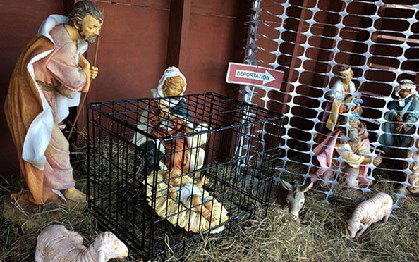 In St. Susanna Parish's Nativity display, Jesus is placed in a metal cage while the wise men are blocked by a fence.