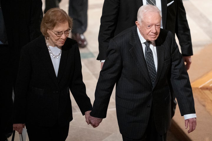 Carter and his wife, Rosalynn, hold hands as they walk through Washington National Cathedral before the memorial service for President George H.W. Bush in December 2018.