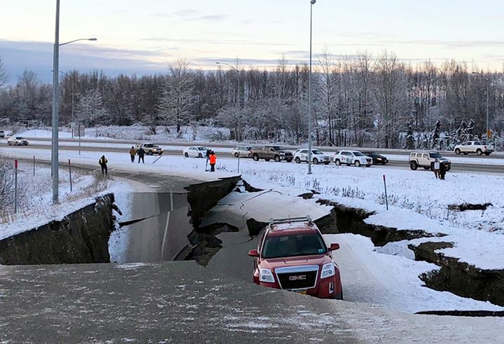 A vehicle is trapped on a section of road that collapsed during an earthquake in Anchorage, Alaska.