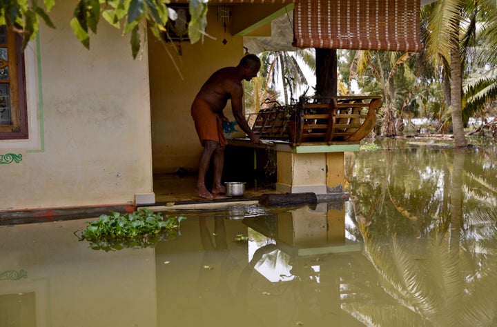 A man stands in his house amid flood waters in Kerala, India — the worst monsoon flooding in a century in the southern Indian state.