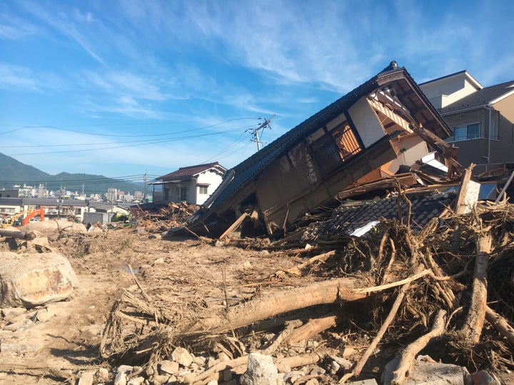 Damaged houses and a mud-covered road in the aftermath of heavy rains in Hiroshima, southwestern Japan.