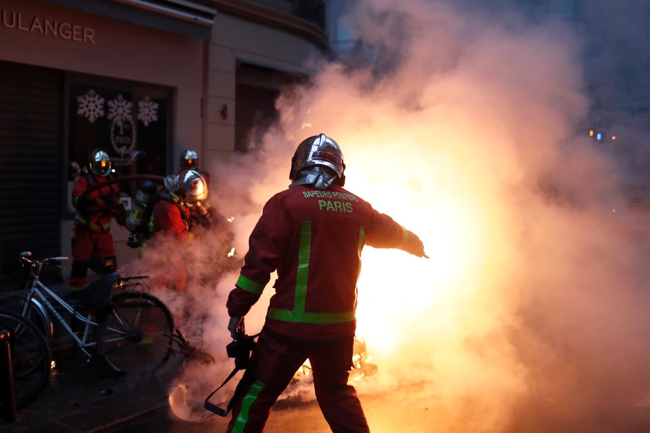 Emergency workers attempt to quash flash fires across Paris on Saturday after riots flared once more.