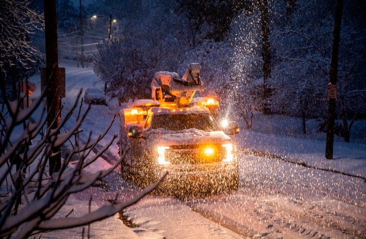 A Duke Energy crew works to restore power in Raleigh, N.C,. as snow continues to fall Sunday morning, Dec. 9, 2018. 