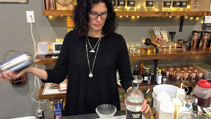 Linda Basina, a co-owner of Copper Crow Distillery, mixes one of the Wisconsin distillery’s signature cocktails. Copper Crow