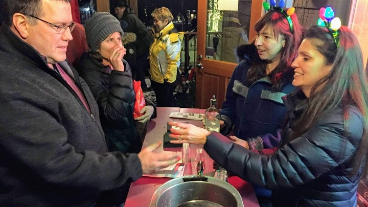 Liz Bodin, one of the Basinas’ daughters, far right, and Angela Botka, second from right, serve cocktails in downtown Bayfield, Wisconsin, to local shoppers. 