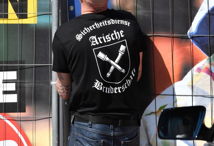 Private security personnel wearing a shirt that reads "Aryan Brotherhood" opens the gate at the venue of the "Schild und Schwert" (Shield and Sword) neo-Nazi festival, in the small eastern German town of Ostritz on April 20, 2018.