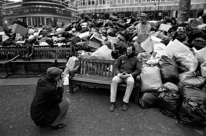 Two Dutch tourists take a photograph in London's Leicester square, where rubbish piled up during the Winter of Discontent.