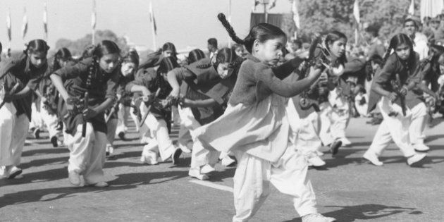 A group of young girls playing instruments and dancing during a march past to celebrate India's 11th Republic Day in Delhi.