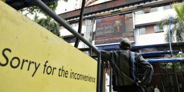 MUMBAI, INDIA - JUNE 25: People look at a screen across a road displaying the Sensex on the facade of the Bombay Stock Exchange building after Britain's exit from the European Union (EU), on June 25, 2016 in Mumbai, India. Britain voted to break away from the European Union on Friday, shattering the unity of a 60-year-old continental bloc, prompting the exit of Prime Minister David Cameron and rattling the world of finance and business. In India, shares fell more than 4% on the news but recovered by half after authorities moved to calm investor worries. The benchmark BSE ended 2.2% down, its biggest single-day percentage fall since February. (Photo by Arijit Sen/Hindustan Times via Getty Images)