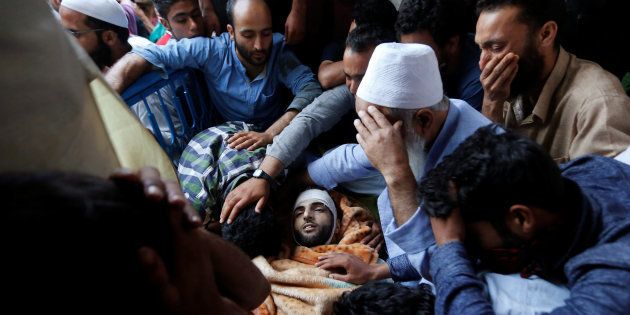 Family members and relatives mourn next to the body of Burhan Wani, a separatist militant leader, during his funeral in Tral, south of Srinagar, July 9, 2016.