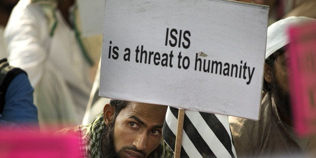 An Indian Muslim man holds a banner during a protest against ISIS in New Delhi, India, Wednesday, Nov. 18, 2015. (AP Photo/Manish Swarup)