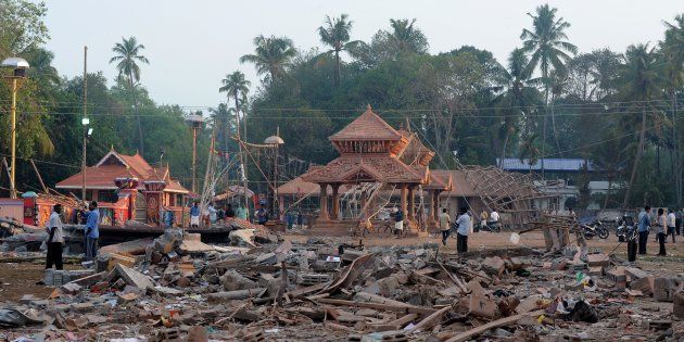 Indian bystanders gather among debris and building wreckage of The Puttingal Devi Temple in Paravur some 60kms north-west of Thiruvananthapuram on April 11, 2016. More than 100 people have died and 350 injured when fireworks meant to be lit for festivities caught fire and exploded near the temple where thousands of people had gathered to witness the festivities on the early hours of April 10. / AFP / MANJUNATH KIRAN (Photo credit should read MANJUNATH KIRAN/AFP/Getty Images)