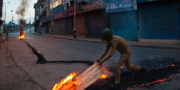 SRINAGAR, KASHMIR, INDIA - JULY 10: Indian government forces douse a burning tire left by the Kashmir protesters in the Ciity center during a curfew after 21 people were killed and more than 400 Injured on July 10, 2016 in Srinagar, the summer capital of Indian Administered Kashmir. The has been more violence in Indian-administered Kashmir after separatist rebel Burhan Wani, 22, was killed in a gunfight with the Indian army on Friday. (Photo by Yawar Nazir/ Getty Images)