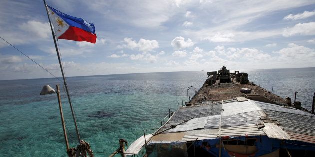 A Philippine flag flutters from BRP Sierra Madre, a dilapidated Philippine Navy ship that has been aground since 1999 and became a Philippine military detachment on the disputed Second Thomas Shoal, part of the Spratly Islands, in the South China Sea March 29, 2014. REUTERS/Erik De Castro/File Photo FROM THE FILES PACKAGE - SEARCH