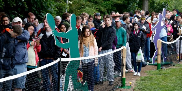 Members of the public queue to enter the grounds on the first day of the All England Lawn Tennis Championships at Wimbledon, England, Monday, June 24, 2013. (AP Photo/Sang Tan)