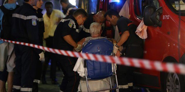 Rescue workers help an injured woman to get in a ambulance on July 15, 2016, after a truck drove into a crowd watching a fireworks display in the French Riviera town of Nice.