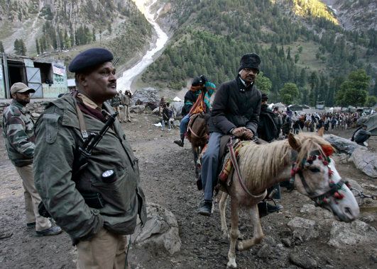 File photo of an Indian police officer keeping guard as Hindu pilgrims on horses proceed to reach the holy cave of Lord Shiva in Amarnath.