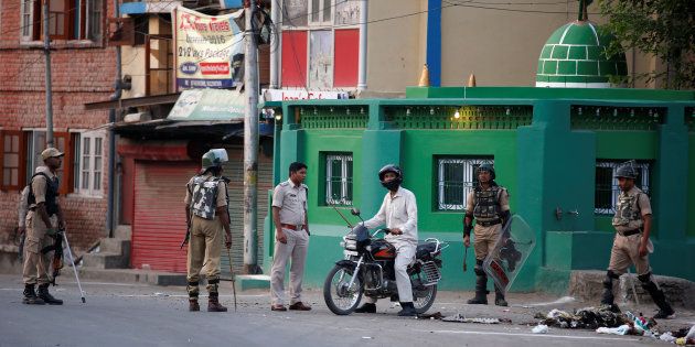 An Indian police officer stops a motorcyclist during a curfew in Srinagar July 13, 2016. REUTERS/Danish Ismail