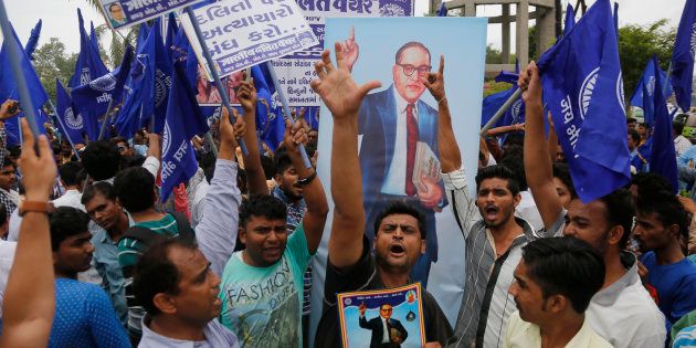 Dalits hold portraits of prominent freedom fighter Bhim Rao Ambedkar and protest against the alleged attack on community members for skinning a cow in Una, in Ahmadabad, India, Tuesday, July 19, 2016. (AP Photo/Ajit Solanki)