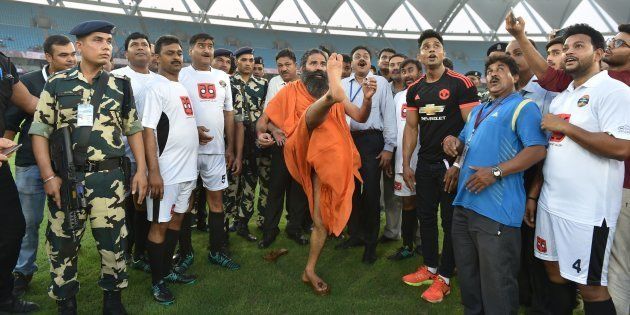 Indian yoga guru Baba Ramdev kicks a football ahead of a charitable football match in New Delhi.