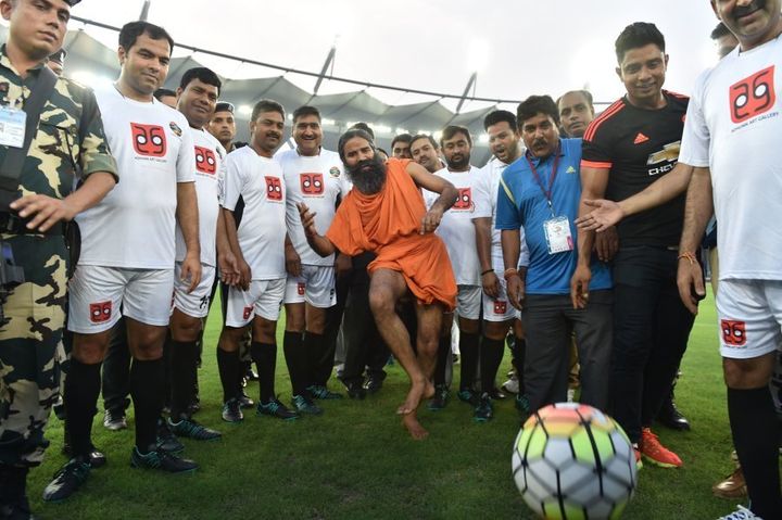 Baba Ramdev kicks a football ahead of a football match in New Delhi.