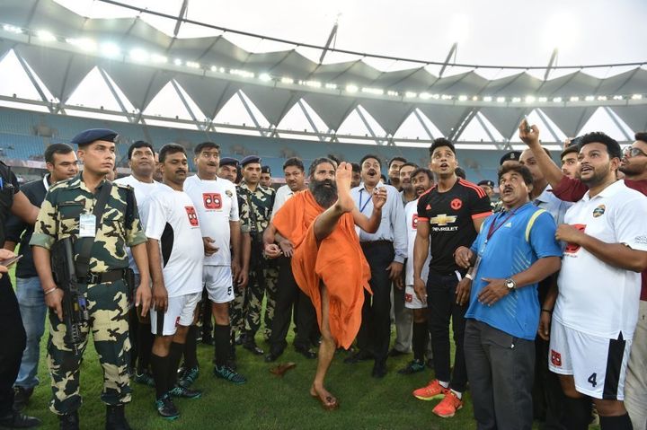 Indian yoga guru Baba Ramdev kicks a football ahead of a charitable football match between Indian Bollywood actors and Indian Parliamentarians in New Delhi on July 24, 2016.