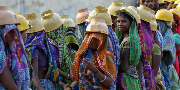 Female labourers wearing helmets take a break from laying underground electricity cables in Ahmedabad, India, March 7, 2016. REUTERS/Amit Dave TPX IMAGES OF THE DAY