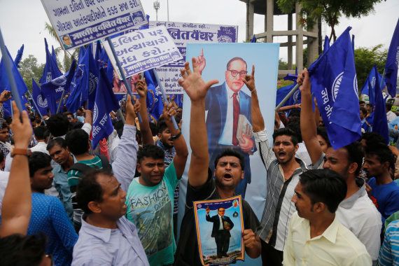 Dalits hold portraits of prominent freedom fighter Bhim Rao Ambedkar and protest against the alleged attack on community members for skinning a cow in Una, in Ahmadabad, Tuesday, July 19, 2016.