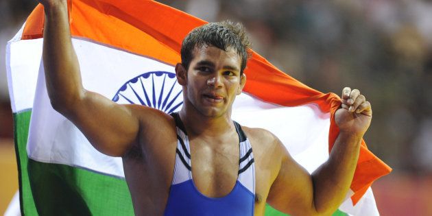 File photo of India's gold medalist Narsingh Panch Yadav holding his national flag after winning the 74kg men's freestye wrestling at the Commonwealth Games in New Delhi on October 9, 2010.