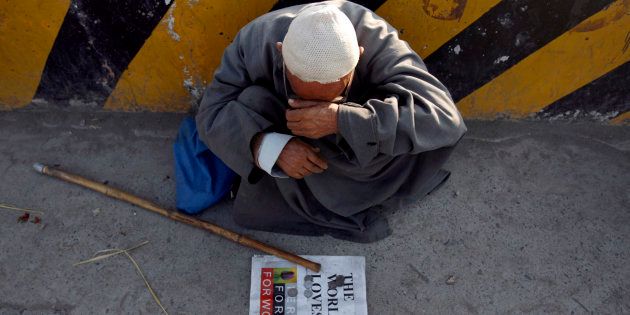 An elderly man sits along a street as he waits for alms in Srinagar August 8, 2007. REUTERS/Adnan Abidi