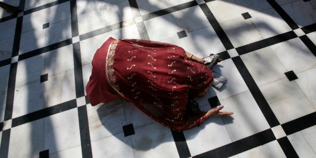 A Hindu woman prays while lying on the floor of a temple on the first day of the nine-day long Navratri festival in Jammu March 31, 2014.
