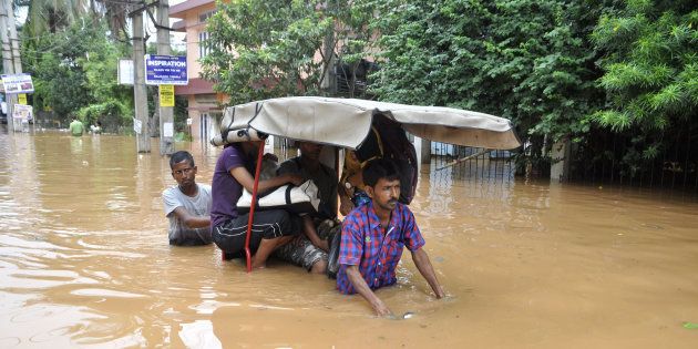 Indian residents navigate floodwaters in the Anilnagar area of Guwahati.