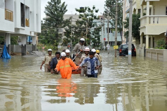 Members of the fire forces and volunteers participate in relief operations in a low lying flooded area of Bangalore. (MANJUNATH KIRAN/AFP/Getty Images)