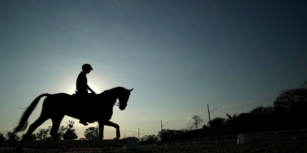 Alex Hua Tian of China works out on his horse at the Olympic Equestrian Center ahead of the 2016 Summer Olympics in Rio de Janeiro, Brazil, Friday, Aug. 5, 2016.