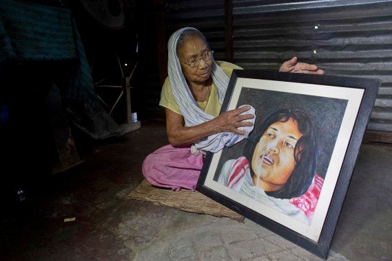 Irom Sakhi Devi, 84, mother of Indian activist Irom Sharmila, holds and cleans a portrait of her daughter as media persons interview her at her home in Imphal. She is disappointed with Sharmila's decision.