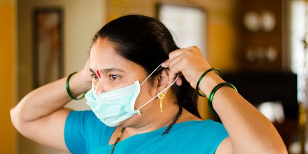 Sneha Avare, a domestic worker at MyDidi, putting on a mask before starting a cleaning job.