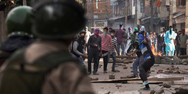Kashmiri Muslim protesters throw stones at Indian security personnels.
