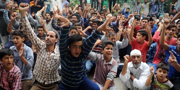 Kashmiri people gesture as they shout anti-Indian and pro-freedom slogans during a protest.
