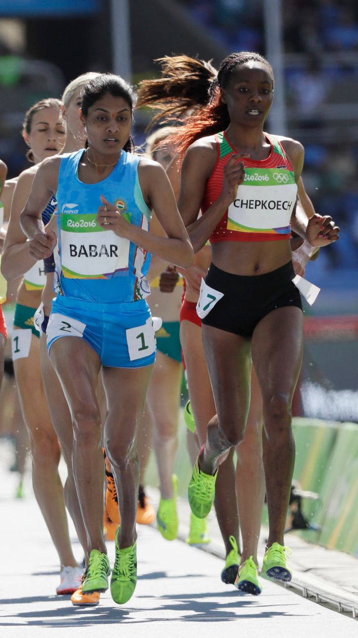 Kenya's Beatrice Chepkoech, right, and India's Lalita Babar, center, competes in a women's 3000-meter steeplechase.