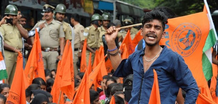 Muslim students and activists of the Akhila Bharatiya Vidyarthi Parishad (ABVP) hold saffron flags as they raise slogans against 'anti-national' forces during a protest in Bangalore on August 17, 2016.