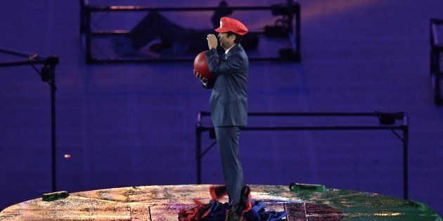 Japanese Prime Minister Shinzo Abe, dressed as Super Mario, holds a red ball during the closing ceremony of the Rio 2016 Olympic Games at the Maracana stadium in Rio de Janeiro on August 21, 2016. / AFP / PHILIPPE LOPEZ (Photo credit should read PHILIPPE LOPEZ/AFP/Getty Images)