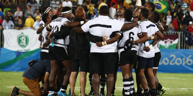 Fiji players and staff huddle as they win gold after the Men's Rugby Sevens Gold medal final match between Fiji and Great Britain.